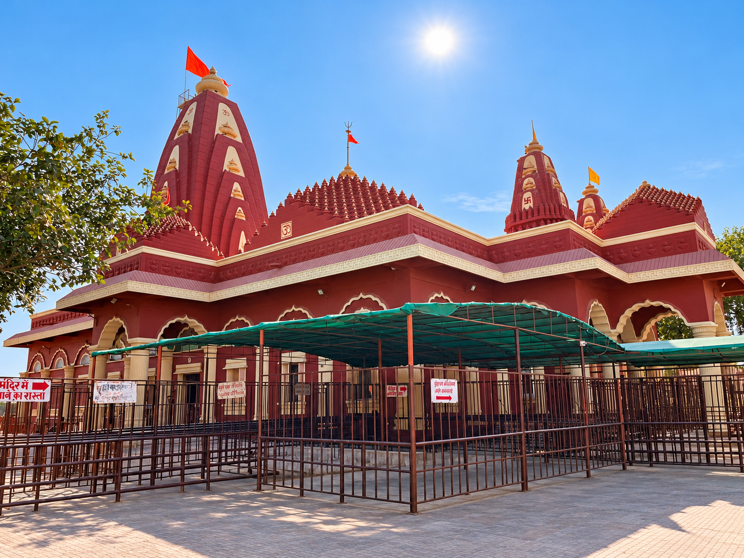 The modern Nageshwar temple exterior, canopies and railings, with visitors removed.