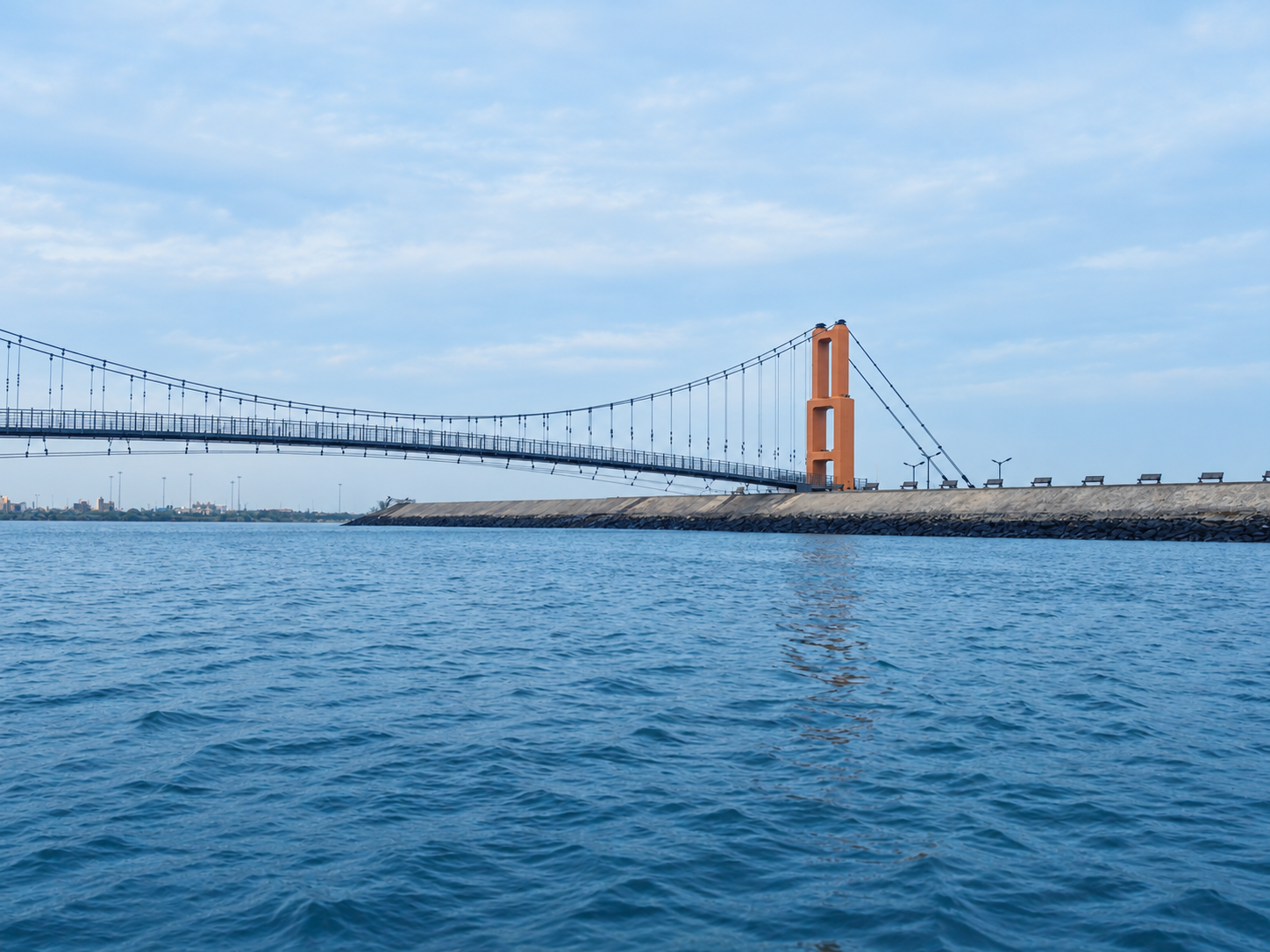 The modern Sudama suspension bridge across Gomti creek, with no people on the deck.